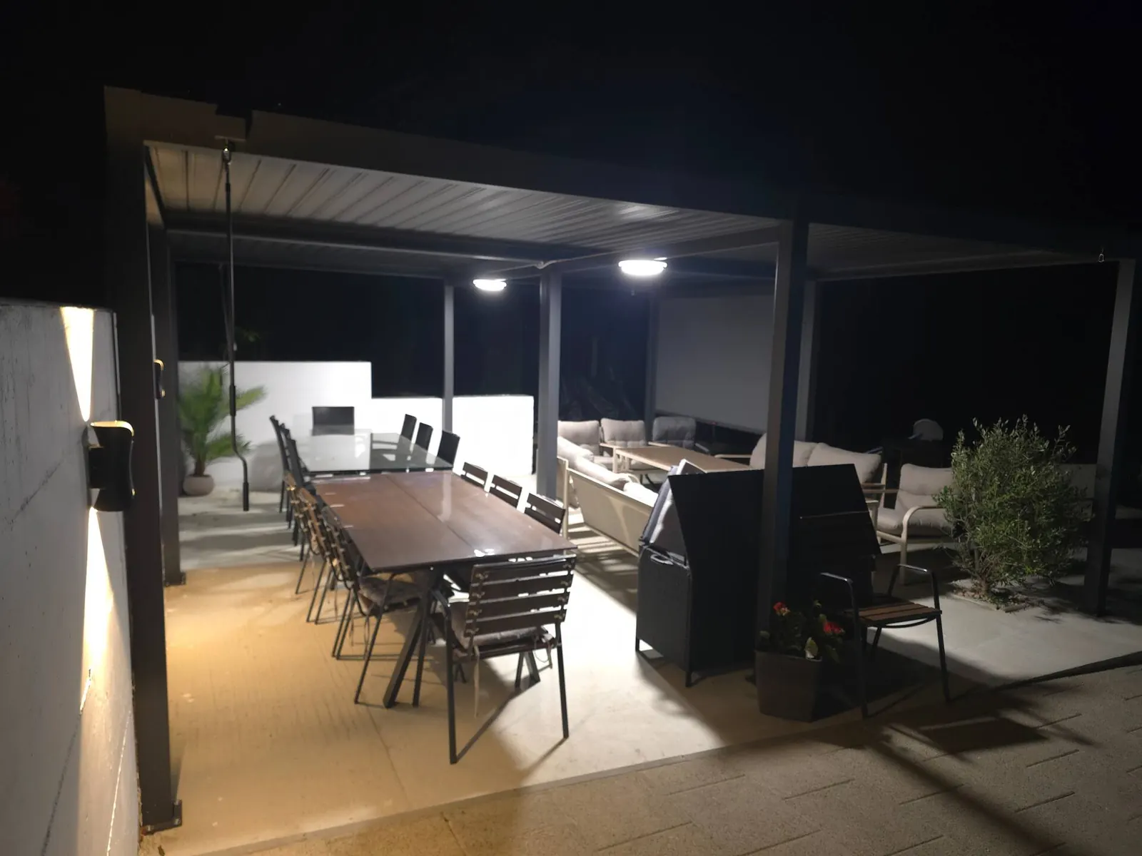 Pergola s dugim stolom noću