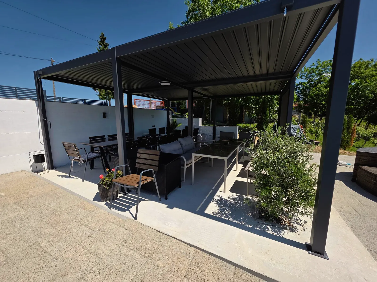 Bioklimatska pergola s lounge garniturom i stolom