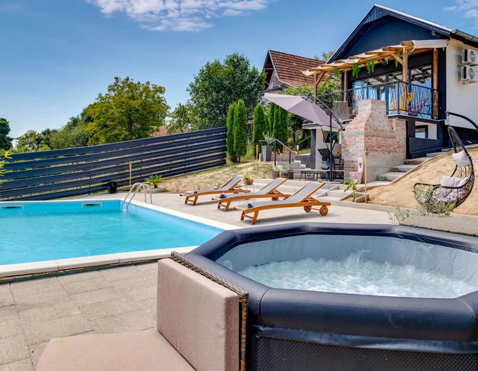 Bazen s ležaljkama i jacuzzi ispred kuće